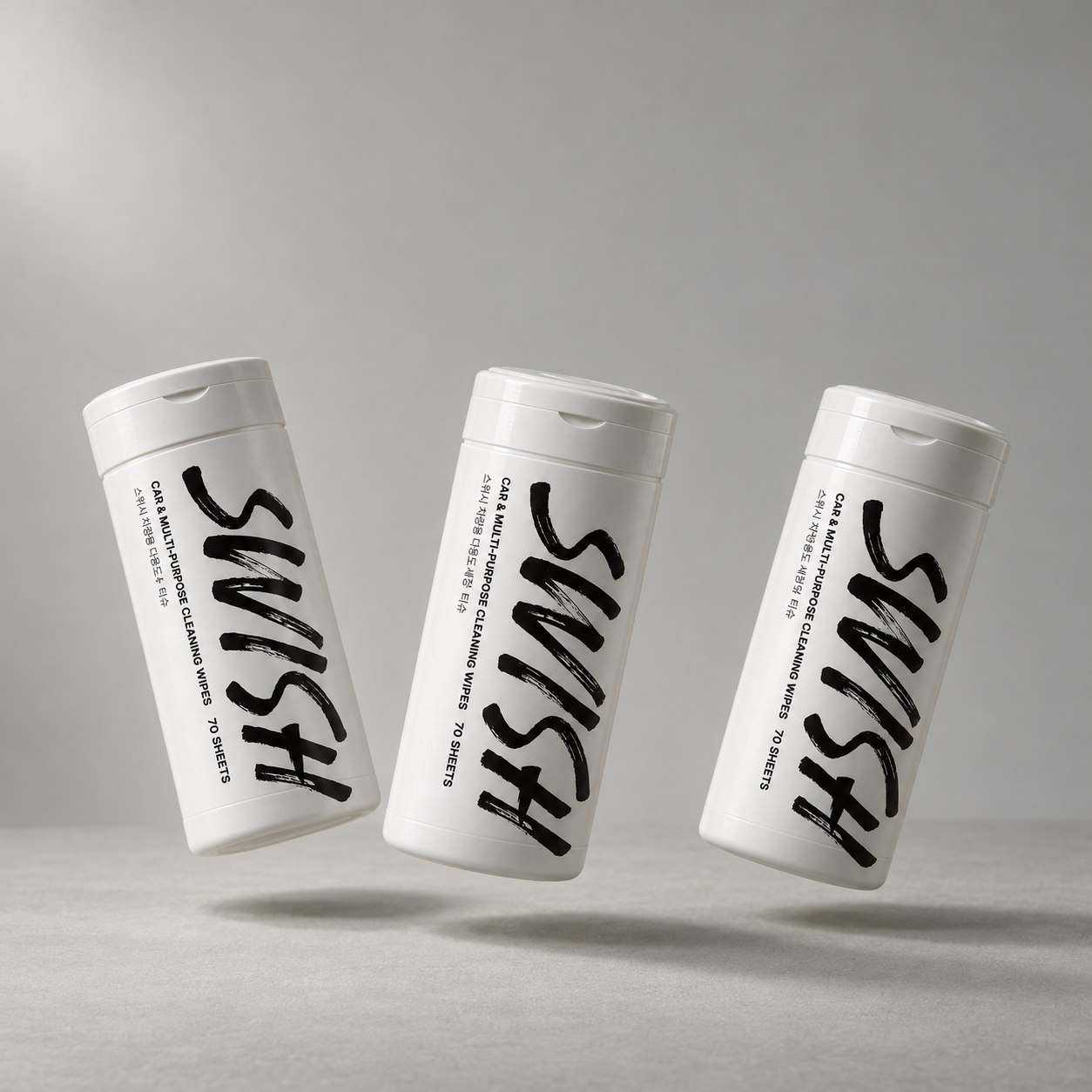 Three white SWISH car cleaning wipe canisters arranged against a soft gray background